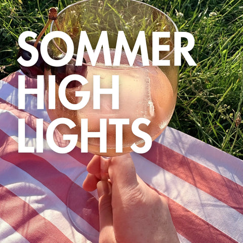 Ein Glas Rosé in der Hand in sommerlicher Stimmung.