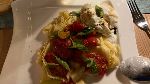 Ein Teller mit Nudeln und ein Glas Sekt dazu.